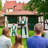 Propst Thomas Berkefeld lauscht der Predigt von Kaplan Matthias Rejnowski, der seinen Pilgerstab mitbrachte.